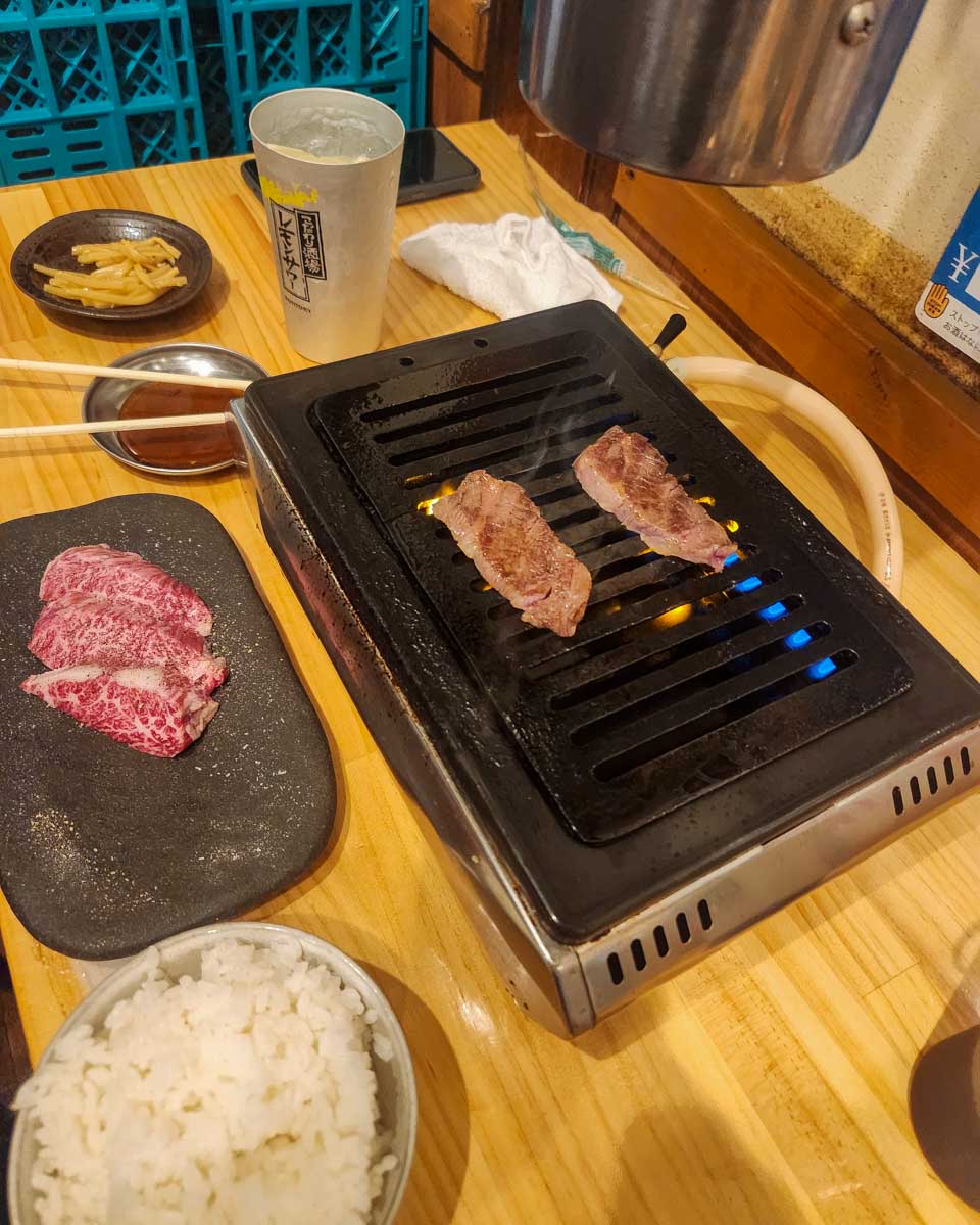 Meat being grilled on the table during a food tour in Tokyo Japan