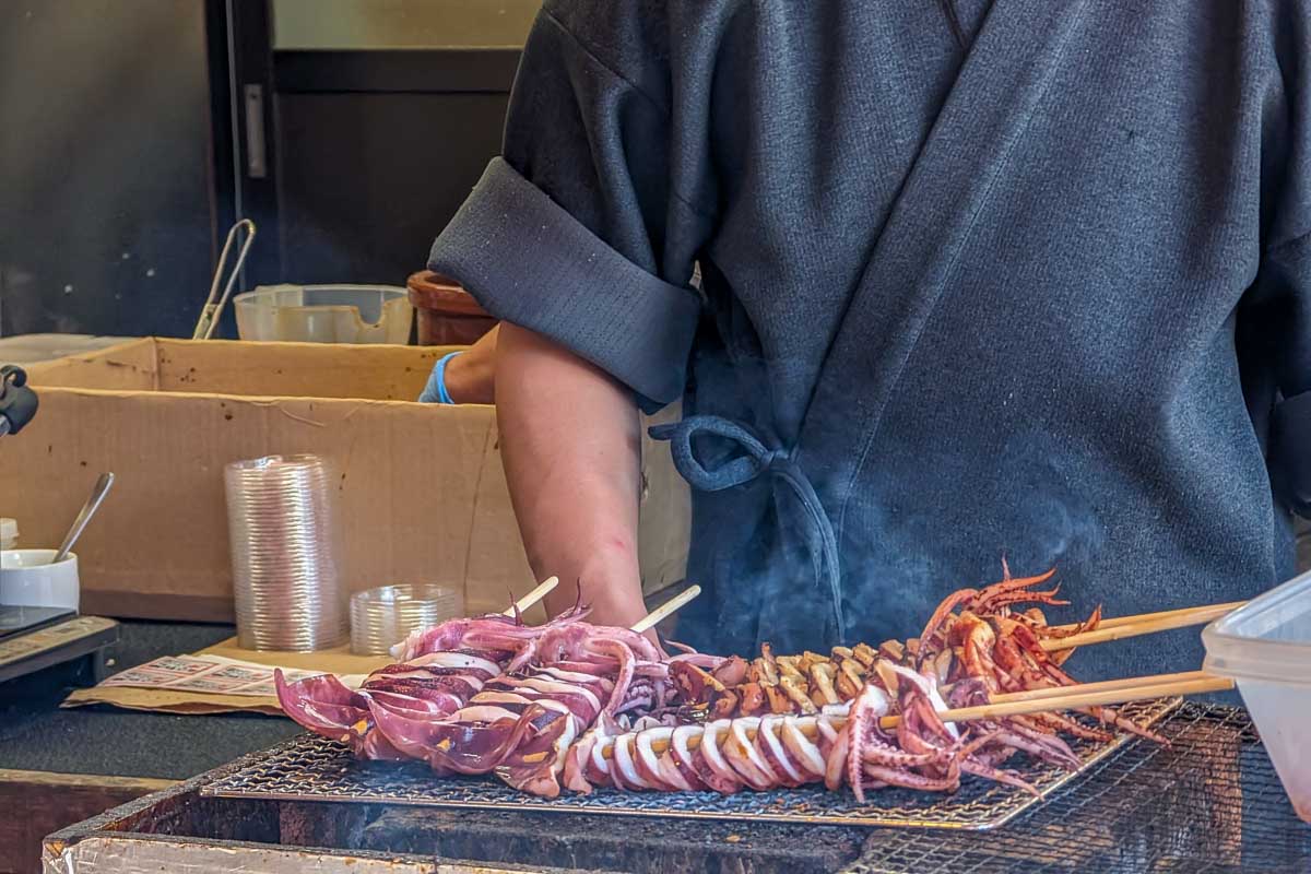 Someone Grilling octopus on a food tour in Tokyo Japan
