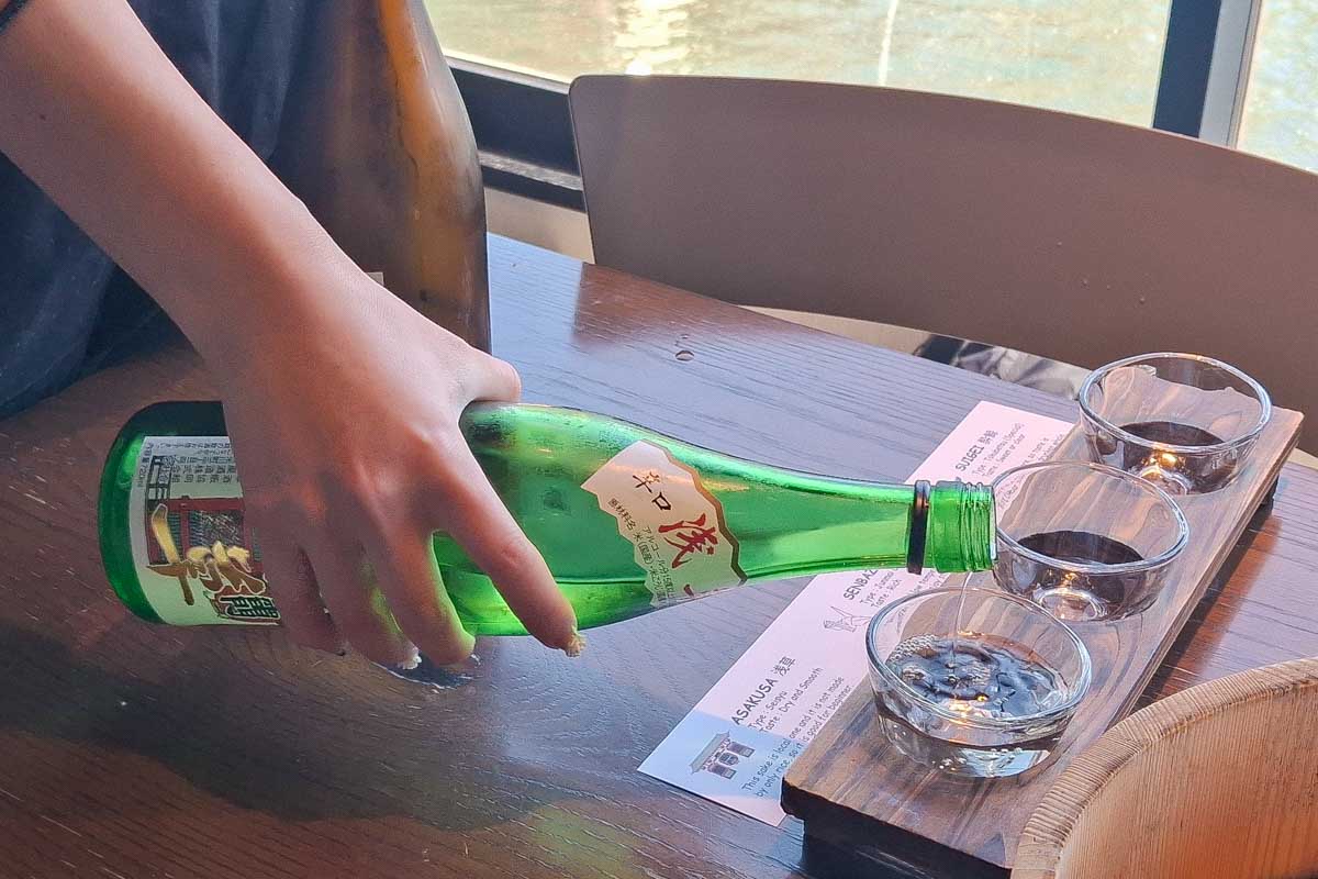 A person pours sake on a sake tour in Kobe Japan