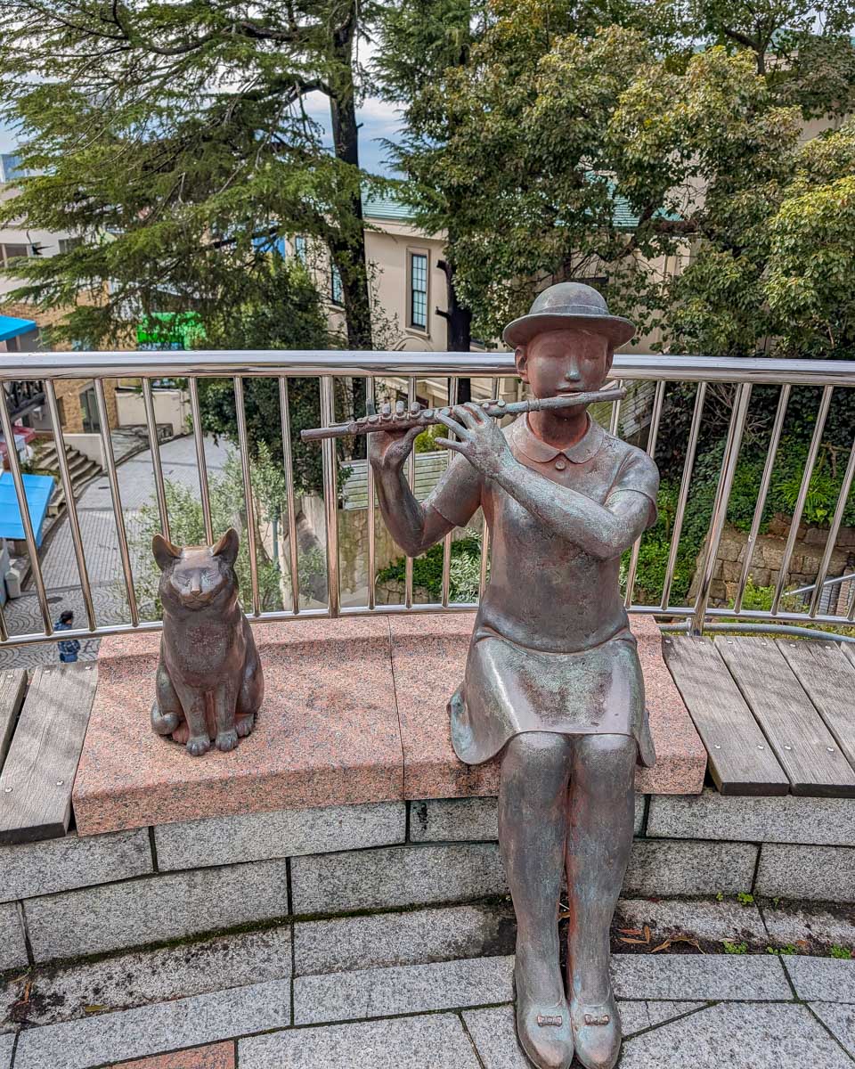 A statue of a girl playing a flute in Kitano Ijinkan-gai in Kobe Japan