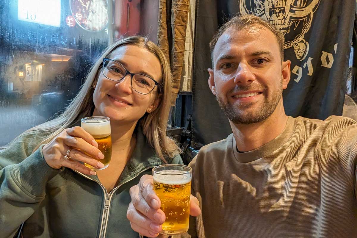 Bailey-and-Daniel-take-a-selfie-while-holding-two-drinks-in-Shibuya-Japan