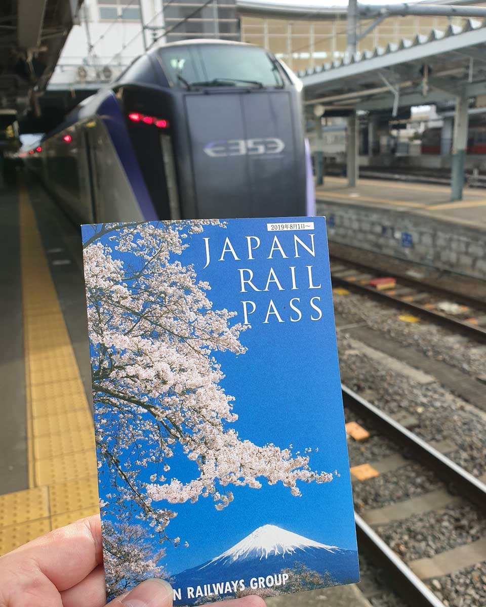 JR Pass held in front of a train in Japan