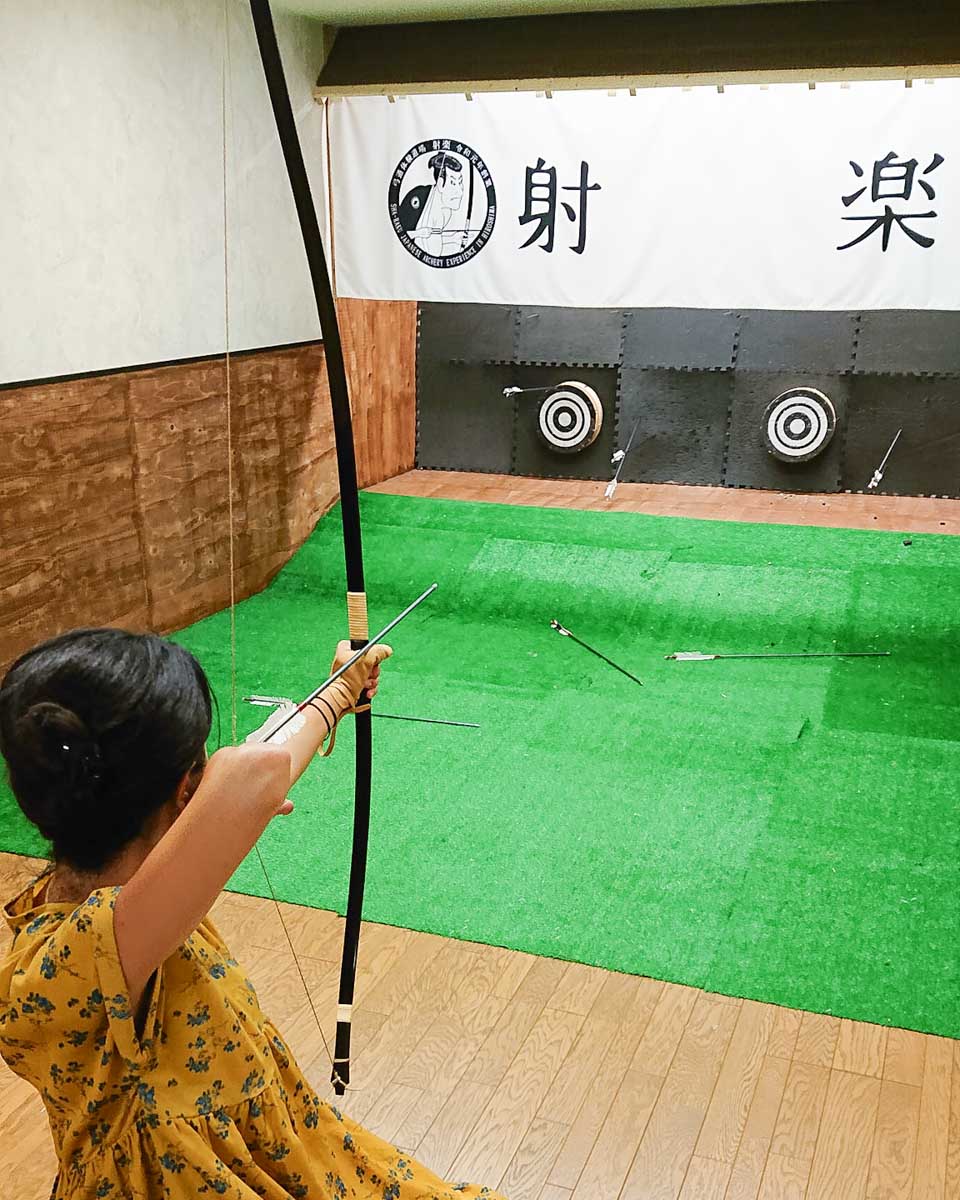 A women aims doing archery with HIROSHIMA CASTLE SHARAKU