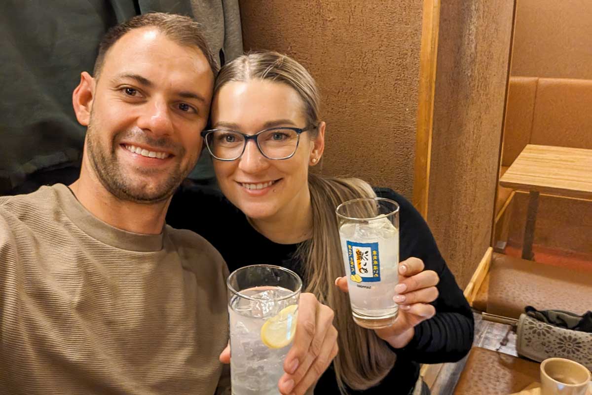 Bailey-and-Daniel-take-a-selfie-while-holding-drinks-in-Takayama-Japan