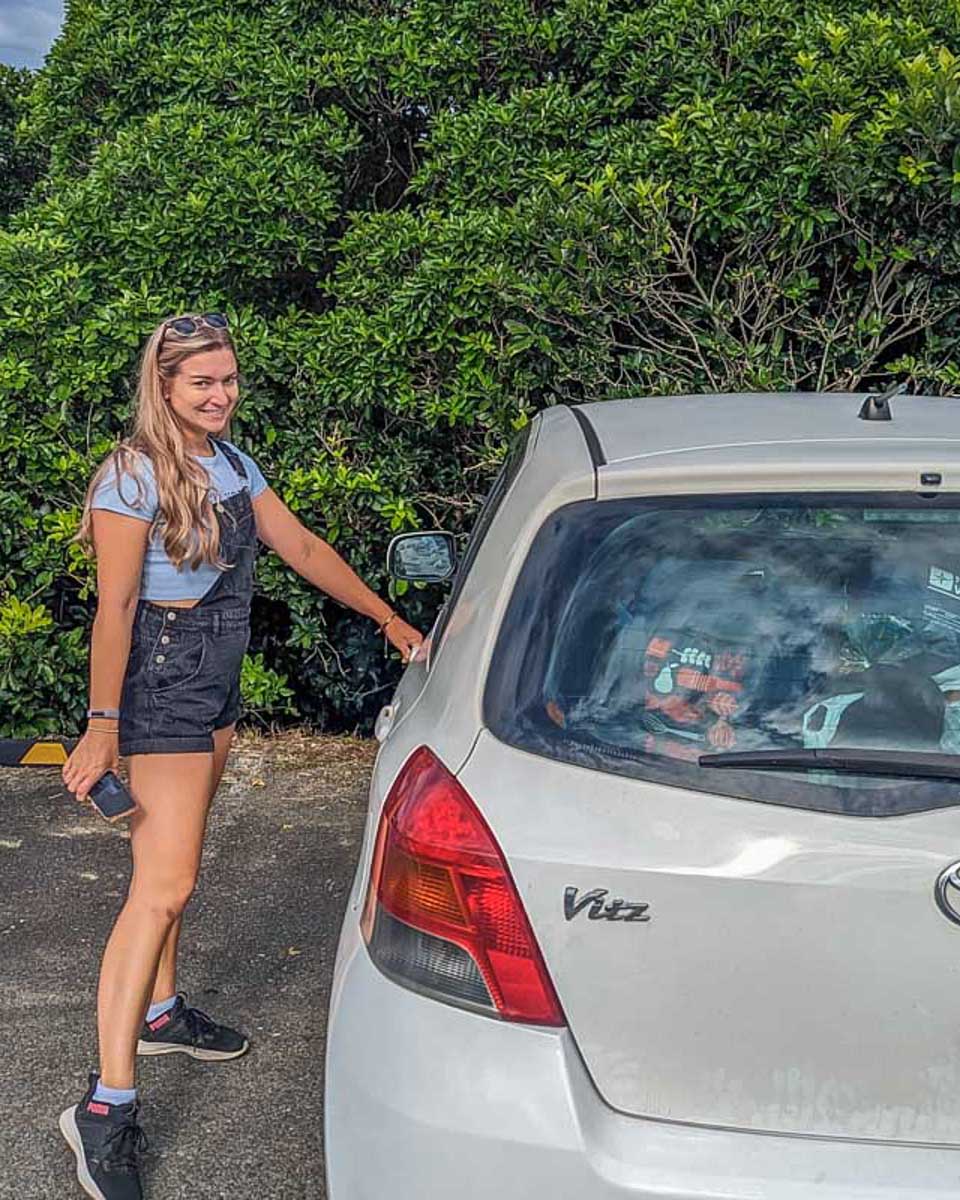 Bailey-poses-for-a-photo-with-her-rental-car-in-Japan
