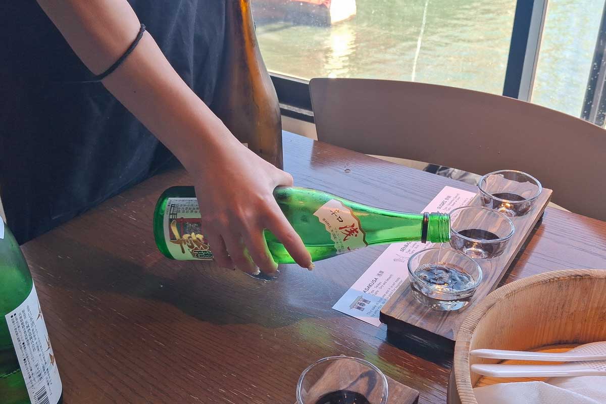 Sake being poured at a sushi making clas in Tokyo Japan