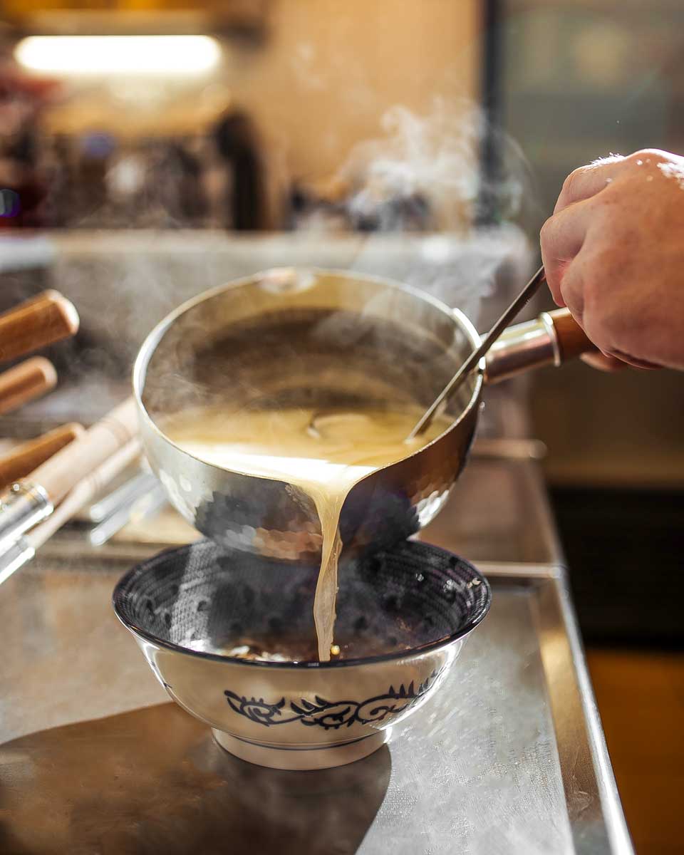A-man-pouring-ramen-broth-during-a-ramen-cooking-class-in-Yokohama Japan